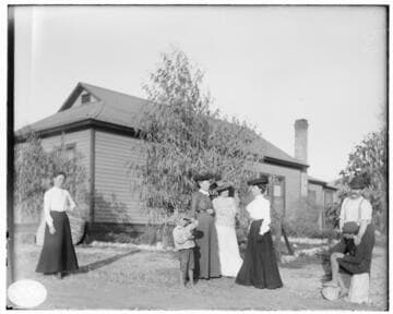 A group of people standing outside a residence