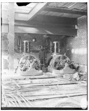 A man standing between two generators