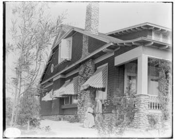 A couple in the garden beside a beautiful 2 story Arts & Crafts Home