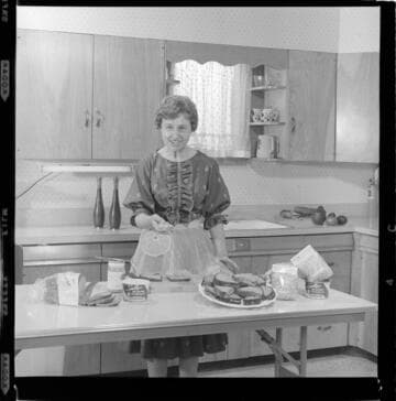 Woman in a teaching kitchen giving a cooking demonstration with 8 variants