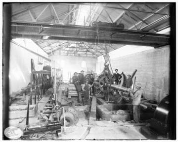 A construction crew gathered around the field that is ready for bearings in the interior of Mill Creek #3 Hydro Plant during construction