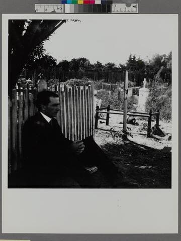Man sitting in the cemetery at Mission San Gabriel Arcangel