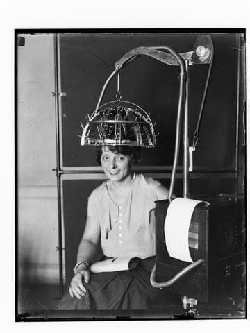 Woman posed with Psychograph Co. machine on her head