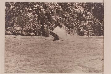 Marston piloting power boat through Granite Falls. The stage is approximately 53,000 cfs