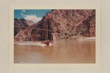 Camera boat returning from picture work above suspension bridge