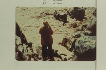 Upset at Mile 232.5. Duane Bishop, Mrs. Gussie Schlosser and Bill Thompson on rock, Frank Wright and John Harper handle rope from shore at left and Pat McCormick in red on shore