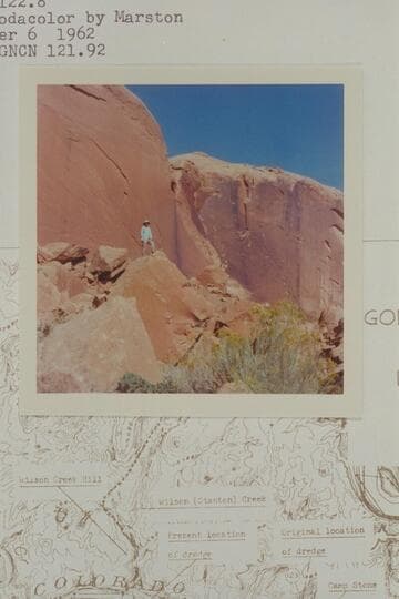 Harry Aleson standing on rocks back of site of dredge assembly, Mile 122.8