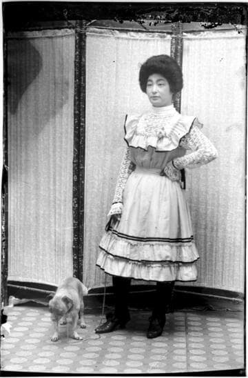 Portrait of a Chinese woman standing, with small dog on leash