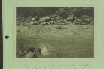 Parley Galloway riding Clyde Eddy through Hance Rapid. Eddy is sitting in the stern of the cockpit and holding to the splash shield