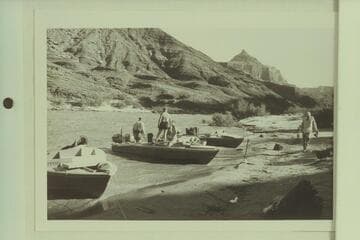 Camp below Temple Butte, Grand Canyon, Mile 66.  Rod Sanderson and Dock Marston are in the "Rattlesnake", Garth Marston stands near the boat and Joe Desloge walks on the beach