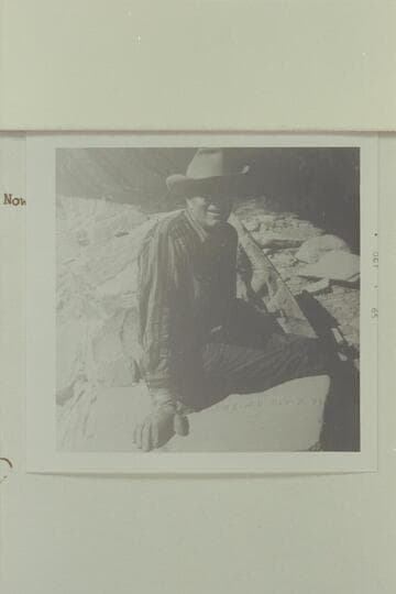 Reeves Baker sits over the "J. W. Black" name which is placed on a rock in a ruin to the left of the Aleson name. It is situated on the left bank of the Escalante, high in the alcoves of the wall; about 1 1/4 mile below 25 Mile Wash