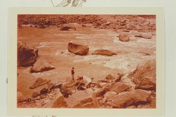 Rapid No. 16 in Cataract Canyon. Dock Marston and Buzz Belknap are checking the Best and McDonald inscriptions. The flat rock over Dock's head trapped the Best Expedition boat 1891, July 22. Mile 204 1/2. Rapid heads at 204.55