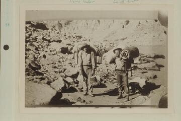 Portage in Cataract Canyon during the survey of the canyon by the USGS party directed by W. R. Chenoweth. Leigh Lint is on the right. A Portage, Harry Tasker and Leigh Lint. LaRue caption: Pack "animals" at Rapid 45
