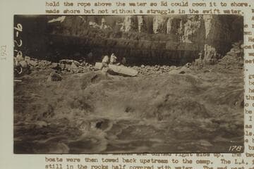USGS boat on the rocks in Dark Canyon Rapid.  USGS photo 178 [on reverse:  Rough water and a damaged boat]
