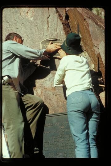 Ranger Jim Bailey and Frankie Strathairn fasten 1934 plaque in wall at Separation Canyon
