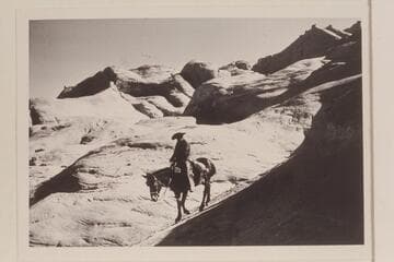Dan Lehi rides down the slick rock on trail from Black Water Creek into Moepitz Canyon