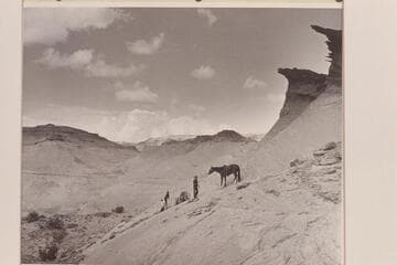 Down the slickrock from the mesa in front of Arch in the Sky at the edge of Navajo Canyon, Arizona. Left to right: Tom Daly; Buck White-hat; Bahe