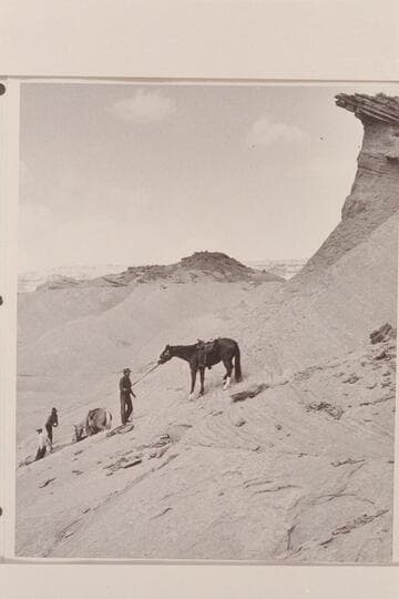 Down the slickrock from the mesa in front of Arch in the Sky at the edge of Navajo Canyon, Arizona. Left to right: Tom Daly; Buck White-hat; Bahe