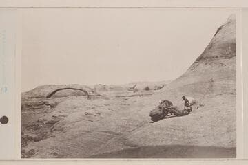 USGS Glen Canyon party. Looking across San Juan Canyon from near Mile 78. Arch in mouth of San Juan