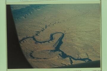 Down Glen Canyon from over Wilson Canyon at Mile 101. The Rincon is lower left. The Kaiparowits is upper left and the Escalante River crosses upper from right to left. Powell Puddle is partially filled