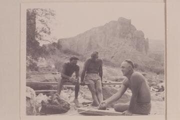 Moulty Fulmer toasting bread at Nancoweap Camp.  Other figures are Nevills and Masland