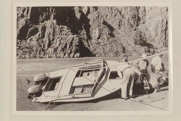 Repairs to "Cactus", Travertine Canyon. Desloge looks into the hatch, Cutler is amused, Bundy watches Sanderson at work and Richey carries a load of dunnage