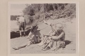 Elgin Pierce prepares the neoprene boat for the Grand Canyon Traverse with Georgie White.  Maradel Marston discusses the situation with Margaret Marston and Rosalind Johnson.  Below Paria Riffle