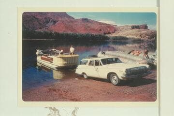 The deck boat is launched at Lees Ferry. Georgie White works on her boloneys at right