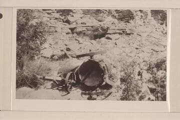 A wrecked boiler at the mouth of Slickhorn Canyon.  Boiler was being lowered to bottom of San Juan Canyon and when near bottom broke loose and rolled to bottom