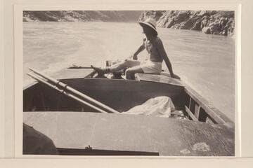Harry Aleson at the controls of the "Up Colorado" running upstream a few miles above Bridge Canyon.  The motor is a 22 1/2 HP Evinrude.  Al Ross was also in the party [his shoulder at left].  Afternoon shadows