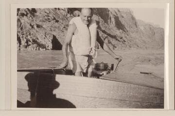 Harry Aleson at the controls of the "Up Colorado" running downstream a few miles above Bridge Canyon to the drill camp at Bridge Canyon. Afternoon light