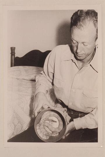 Lorin Bell.  Taken in the Boulder Dam Hotel immediately following the Nevills first Grand Canyon run in 1938.  He exhibits in the can a white rattlesnake which he caught somewhere along the river and kept as a pet for some time thereafter