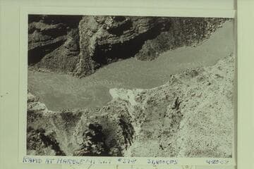 Rapid at mouth of Twenty-two Mile Wash. The fan is at the mouth of the wash which enters the river at Mile 21.55. The beach at left is the location of the Stanton camp of July 12-13, 1889