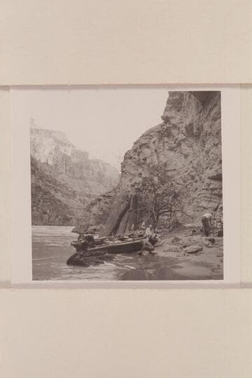 Camp at right bank of river below mouth of Supai Creek.  Ballard washes dishes at edge of river, Joe polishes dishes as he sits on boat, Rod at left, works on motors and Bob picks up and packs the food