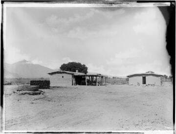 Adobe structure; wagons under shed roof