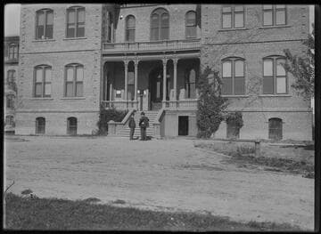 A group of men standing in front of Morrill Hall, University of Nevada, Reno
