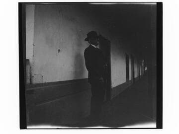 Man standing in corridor of an adobe