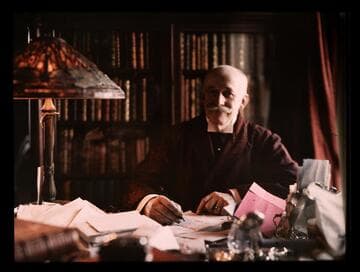 Portrait of Henry E. Huntington seated behind his desk in the study of his New York home, 1916