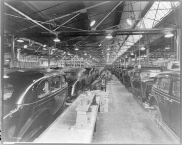 Automobile plant with long rows of 1938 sedans being upholstered on assembly line