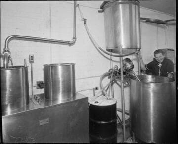 Man mixing incredients in a large container in kitchen