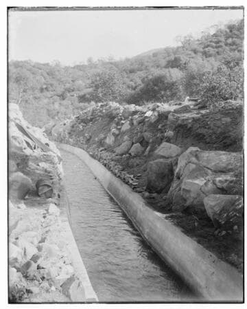 A ditch full of water at Kaweah #2 Hydro Plant. The photo shows hills and rocks in the background