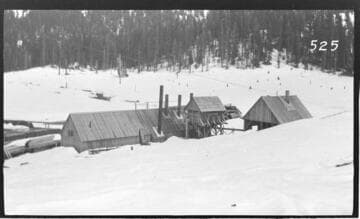 Several wooden buildings in a snow scene at Wolverton Reservoir