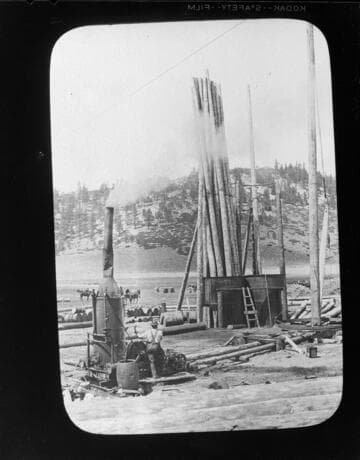 Steam donkey and poles at construction site