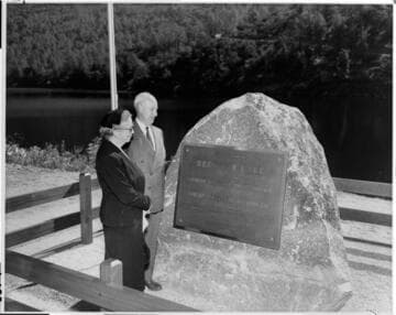 Dee and Dave Redinger look at the plaque commemorating the naming of the reservoir behind Dam #7
