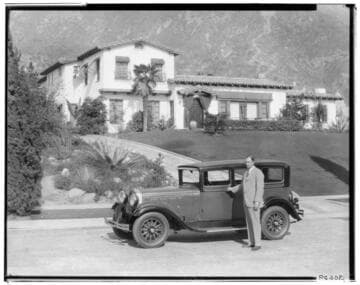 Man and automobile in front of a house