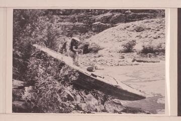 Tony Backus' boat the "Illinois Girl" on the rocks at the head of the Canyon of Lodore. Buzz Homstrom looking into the cockpit