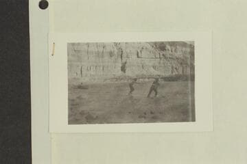 Stone's visit to Glen Canyon. One man by a boat, two men pulling boat upstream