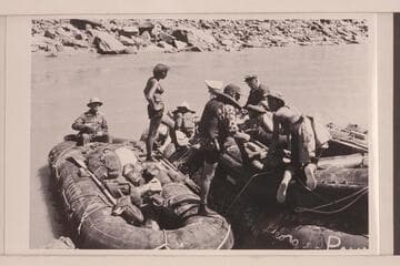 The "Queen Mary" of the Georgie White fleet. Three pontoons tied together and a 10-man neoprene tied on top of the middle unit. Georgie White is standing near the stern