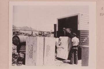 Evinrude Big Twin Outboards arrive at Boulder City.  MacDonald is helping with the unloading at left as Jimmy Jordan watches the operation at the right
