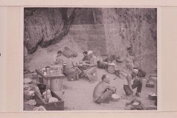 Breakfast at camp above mouth of Clear Creek. At the table are Ian Campbell, John Stark, Bob Sharp, Merrill Spencer. At the fire are Owen Clark and Frank Dodge